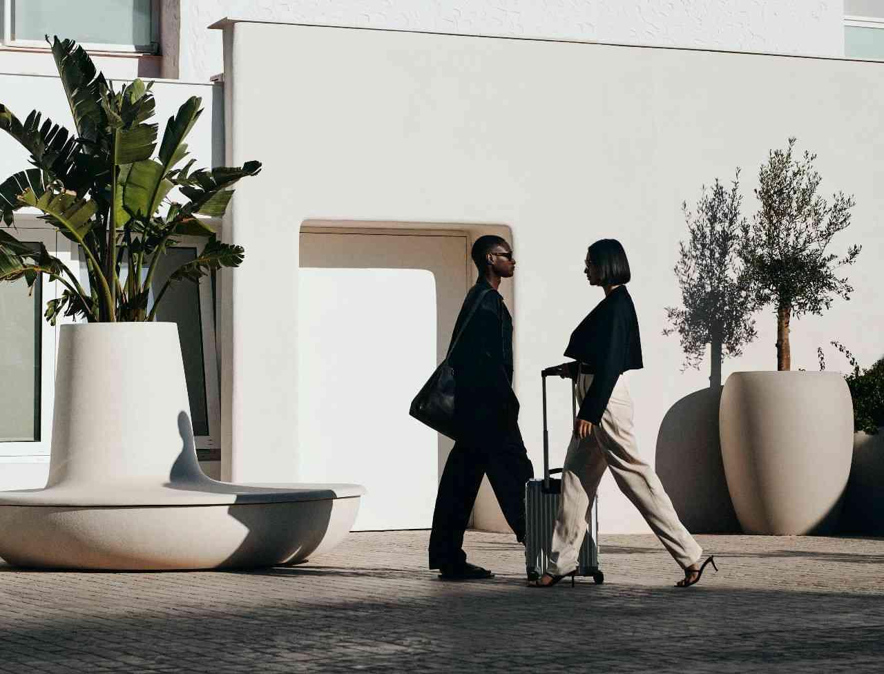 dos personas caminando afuera vestidas de blanco y negro